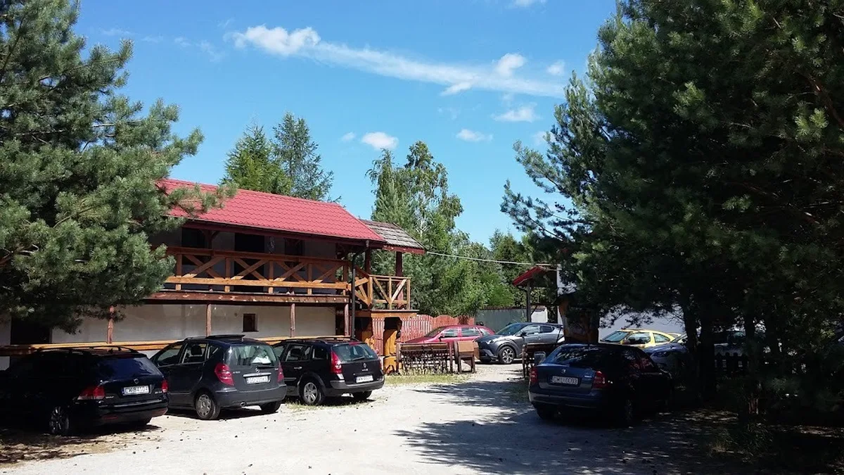Parking i budynek wśród sosen latem AgroFarma