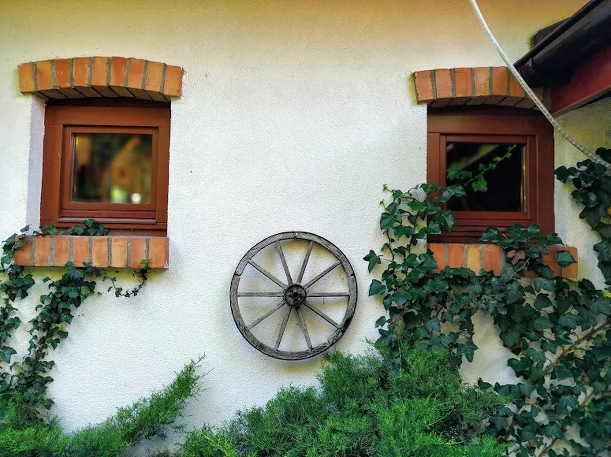 Rustykalny detal ściany z oknami i kołem