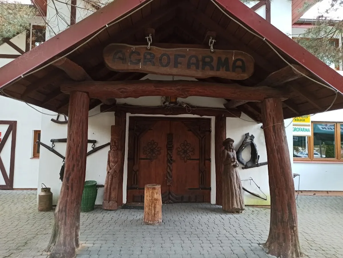 Wejście główne z szyldem i rzeźbami AgroFarma Gołaszewo