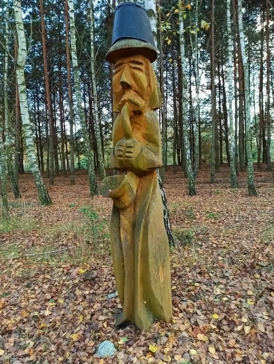 Rzeźba dziada z wiadrem w lesie