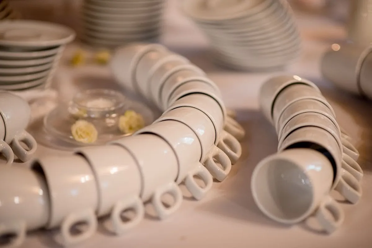 Stosy białych filiżanek i talerzy