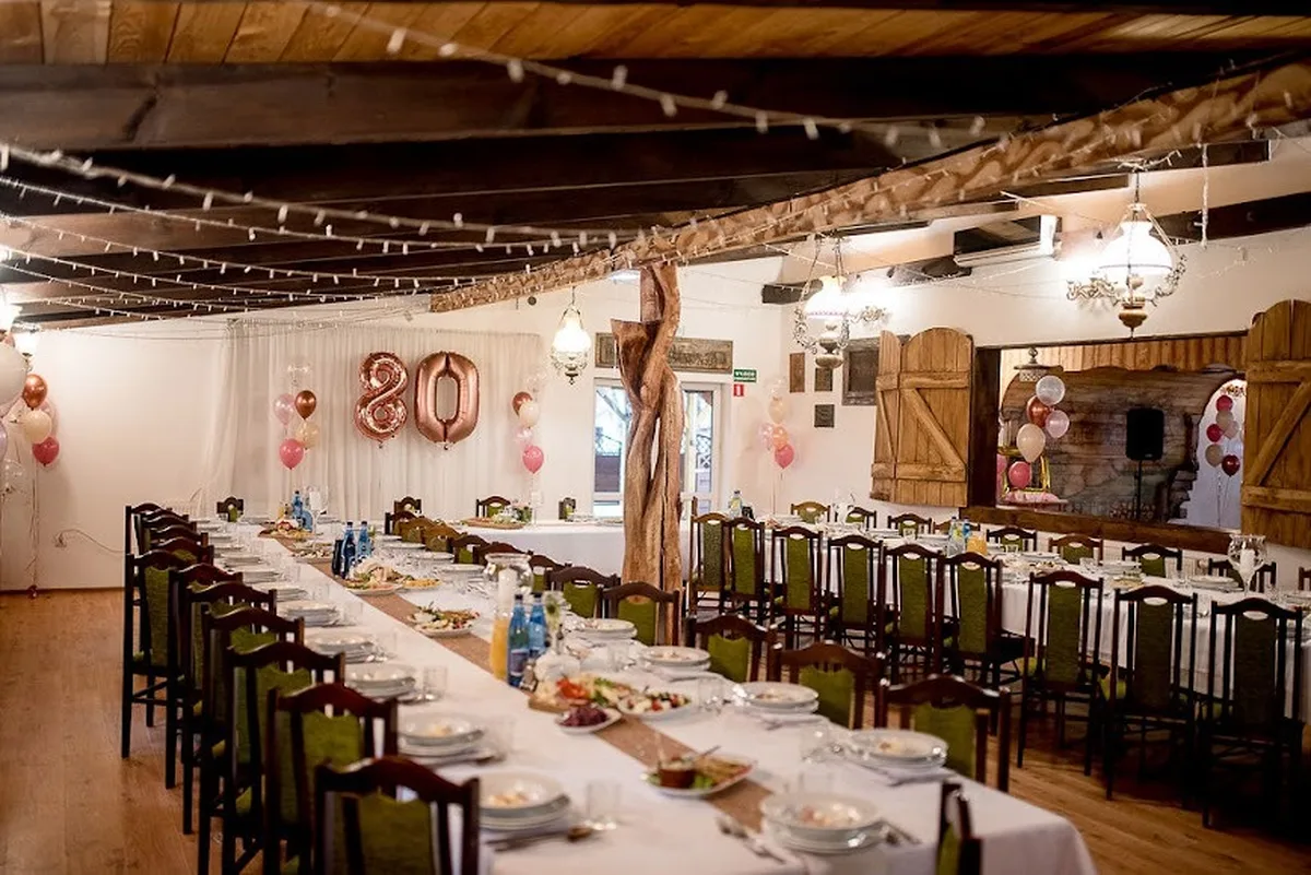 Sala urodzinowa z balonami i nakrytymi stołami