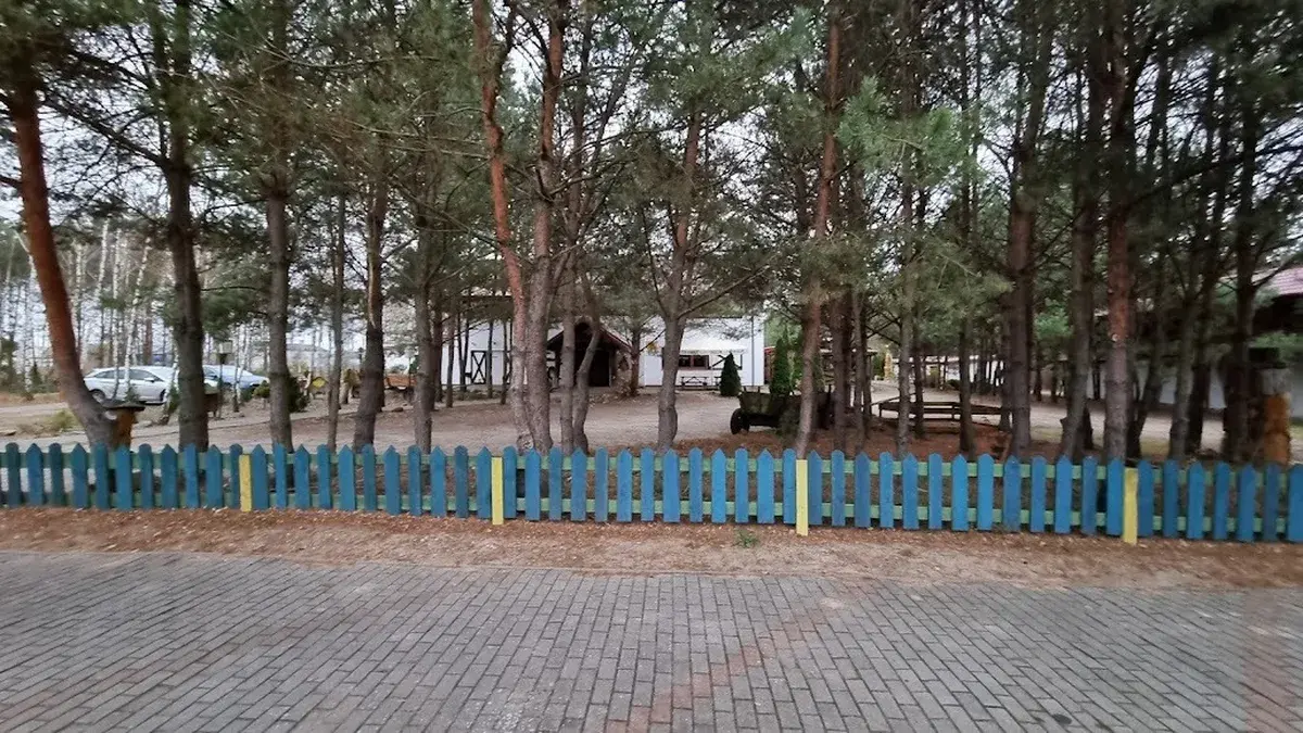 Teren AgroFarmy z ogrodzeniem i drzewami