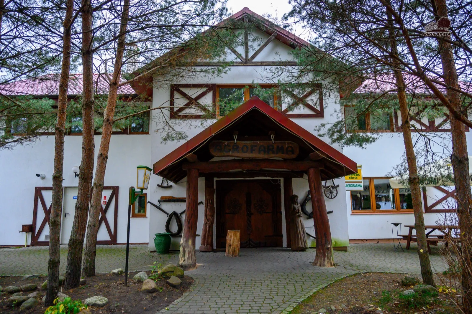 Budynek główny z szyldem AgroFarma — drewniane wejście i rustykalne detale