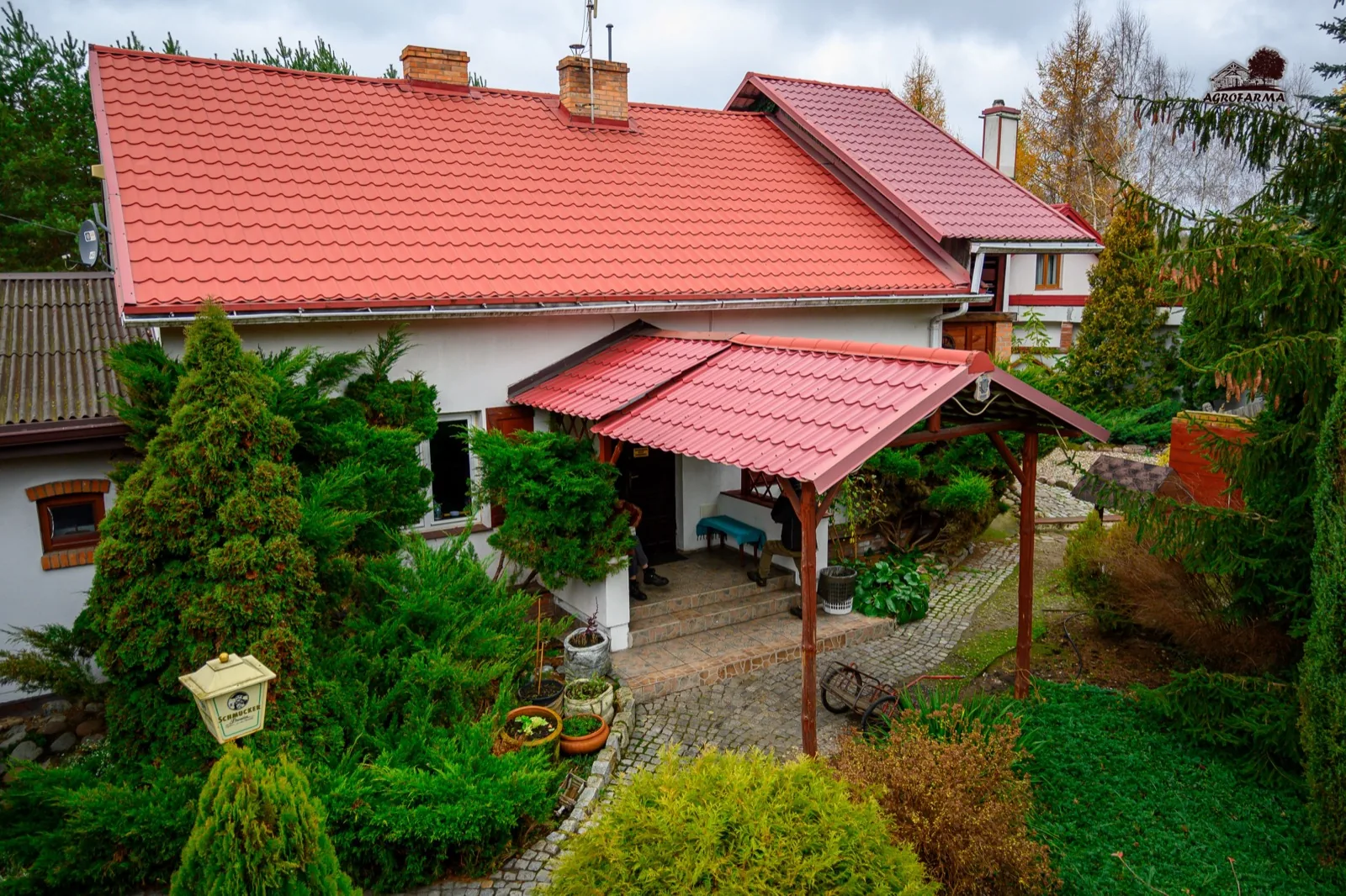 Budynek mieszkalny z czerwonym dachem wśród zieleni