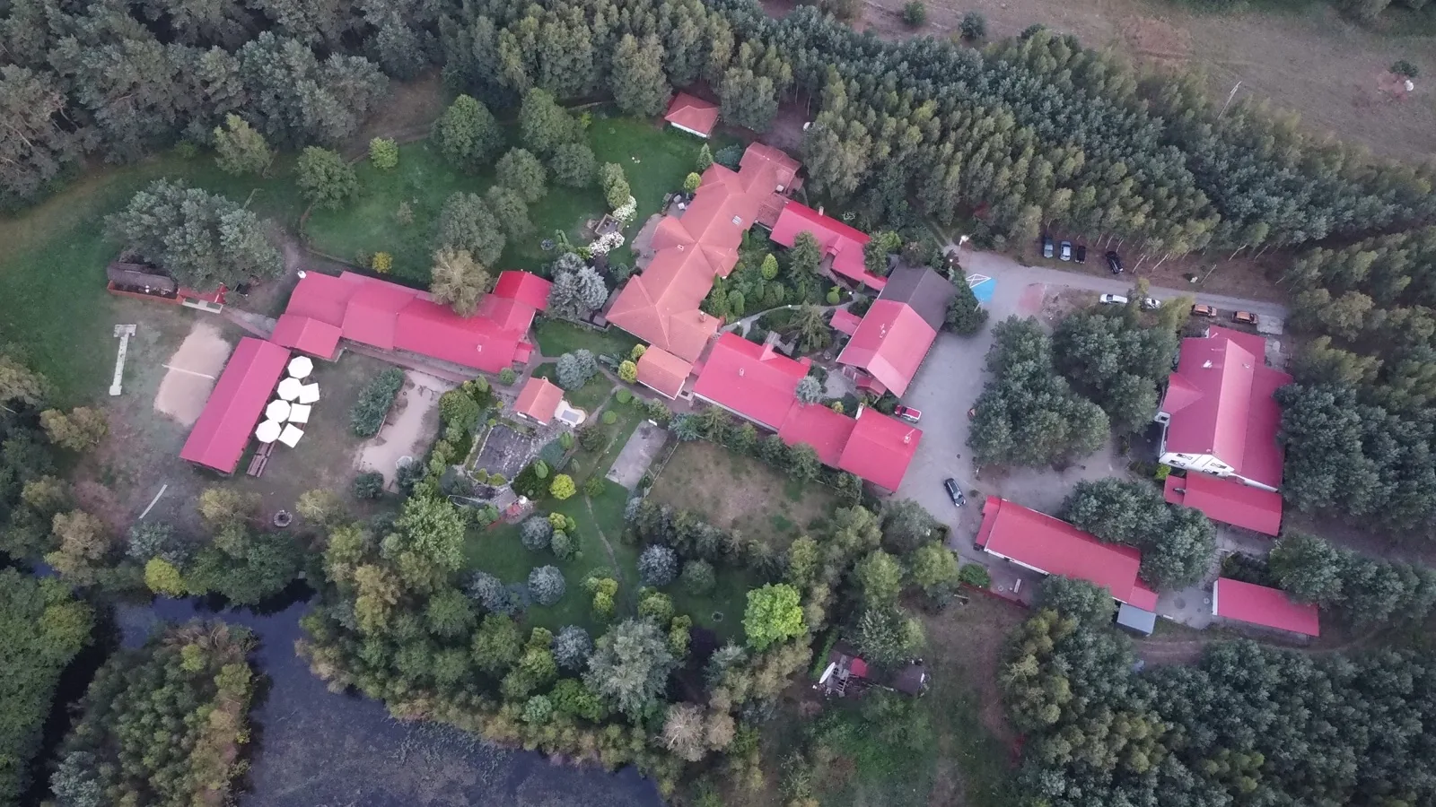 Widok z lotu ptaka na AgroFarma Gołaszewo latem — kompleks budynków w otoczeniu lasu