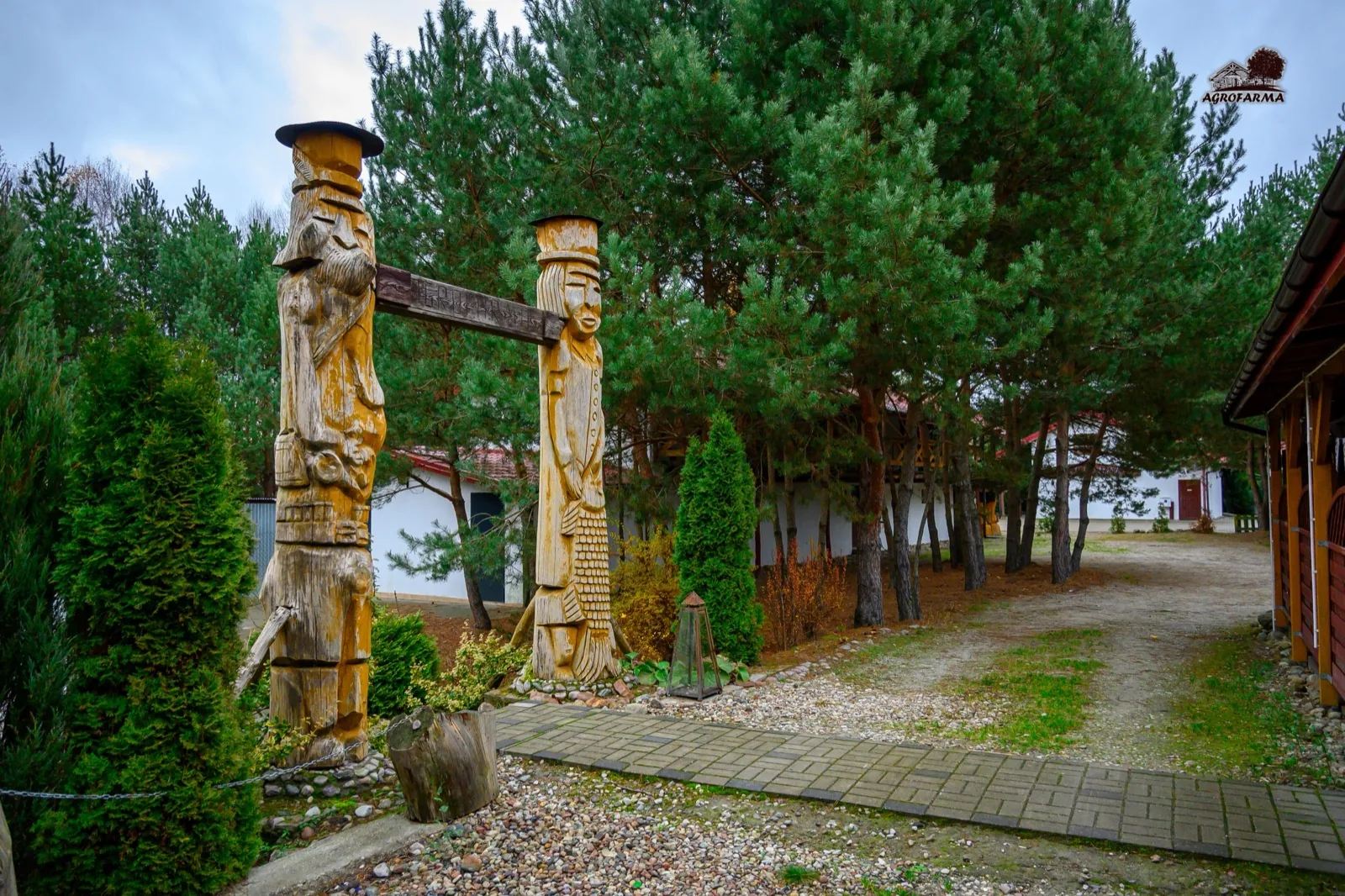 Drewniane rzeźby słowiańskie przy bramie wejściowej AgroFarma